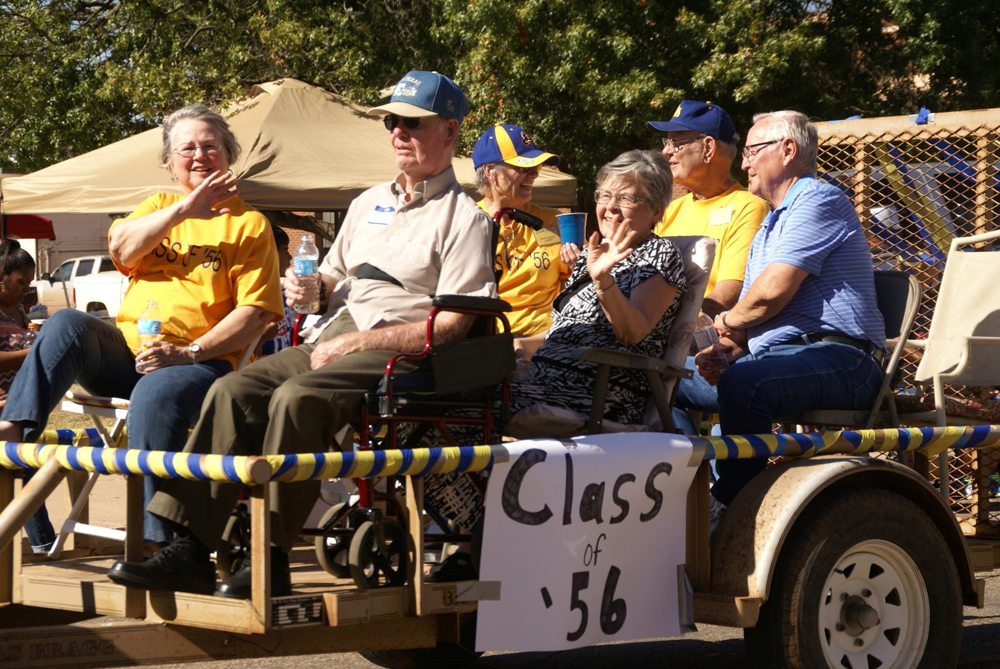 A group of people all hopped on an allegory car with the poster of "Class of '56"