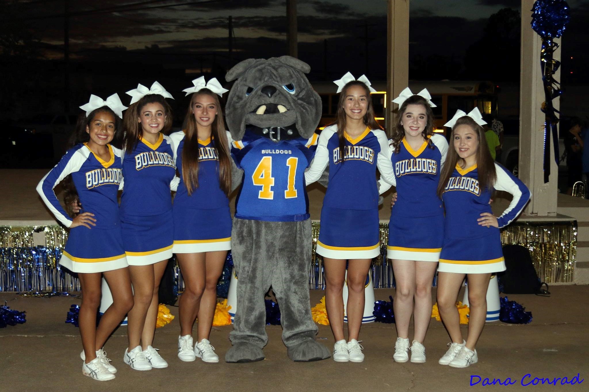 The cheerleaders all posing with the school's mascot.