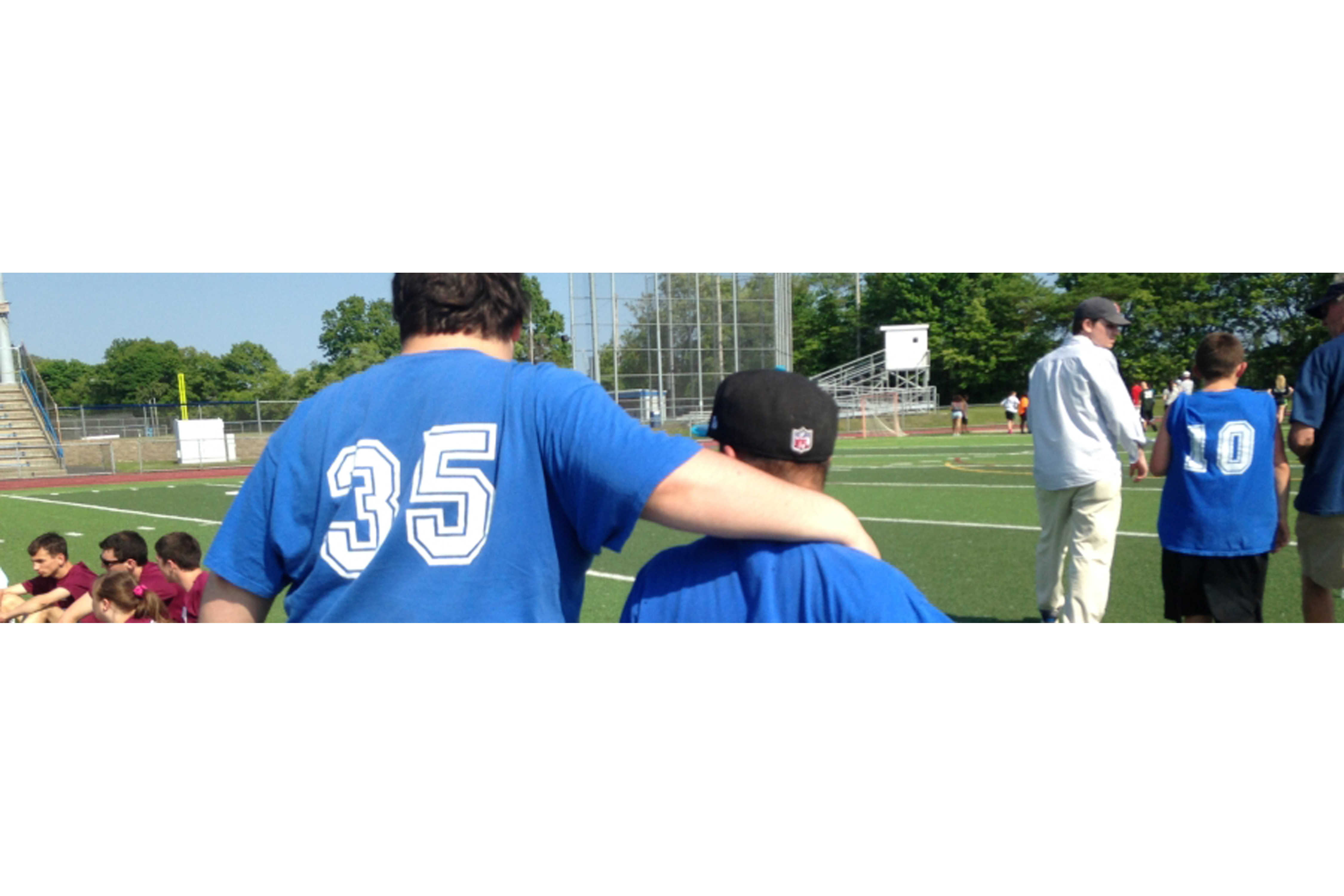 A coach walking outside with an athletic student