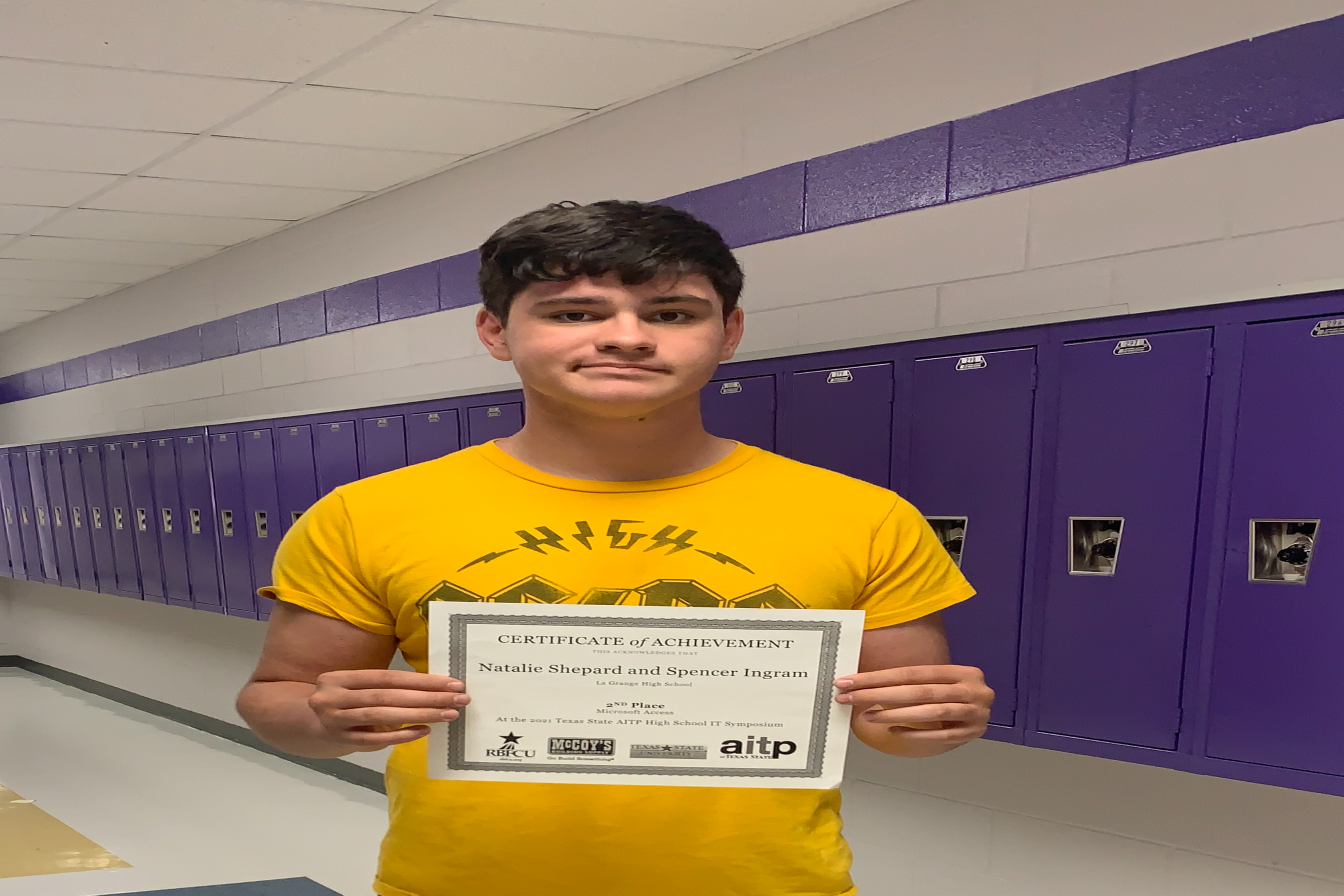 Tech student holds up certificate of achievement 