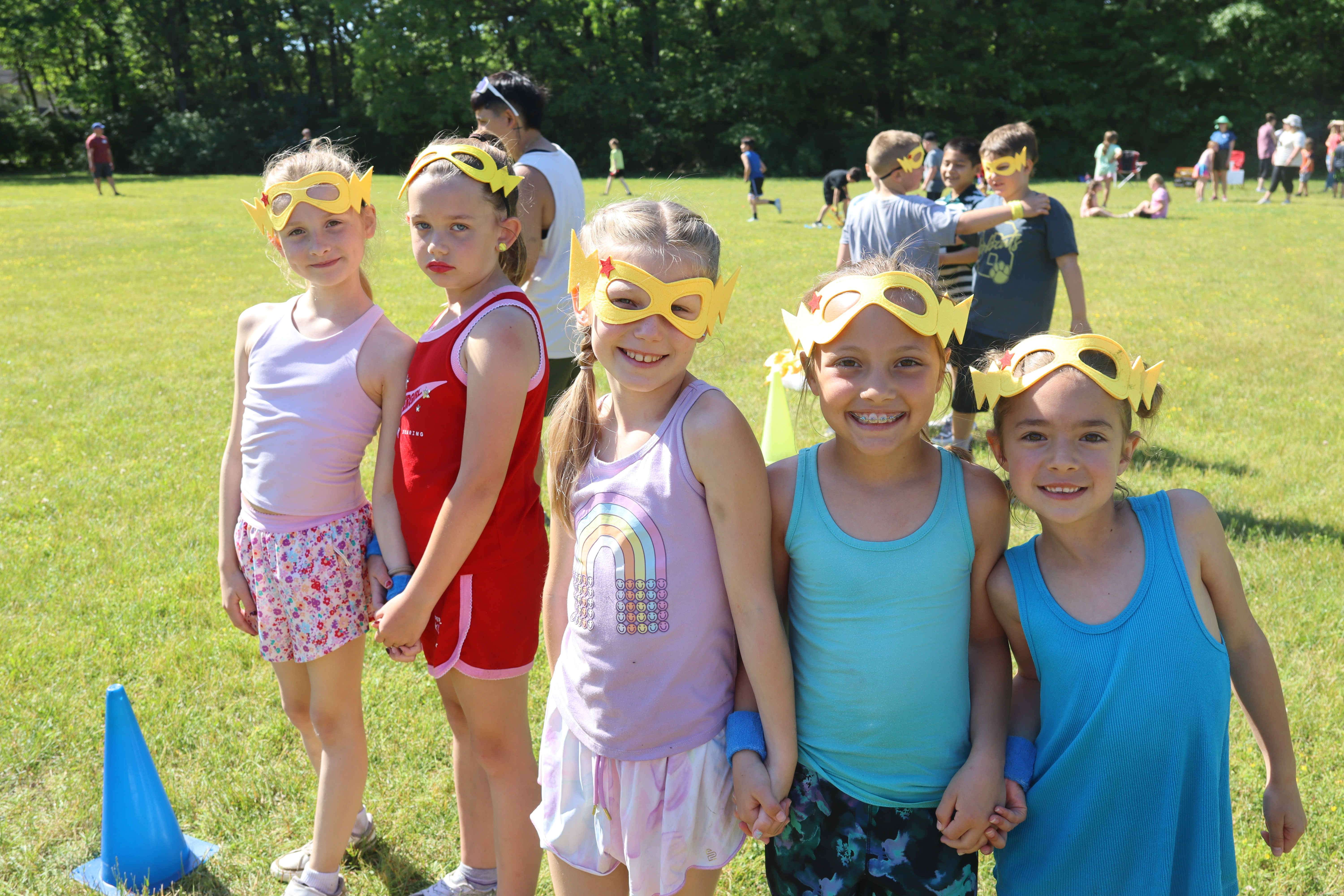 group of four girls in superhero masks on playground