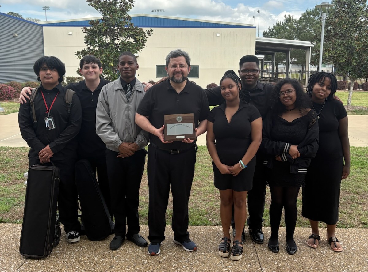 Orchestra group posing with trophy