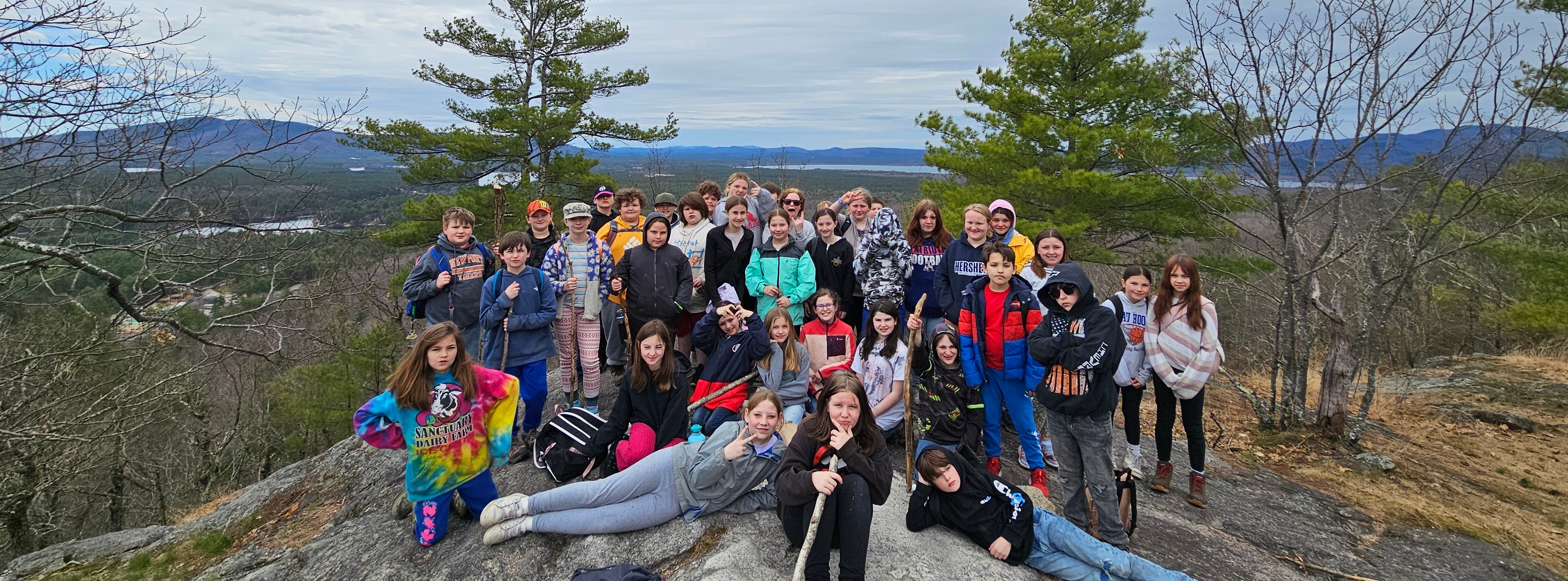 group of students gathered on a large rock