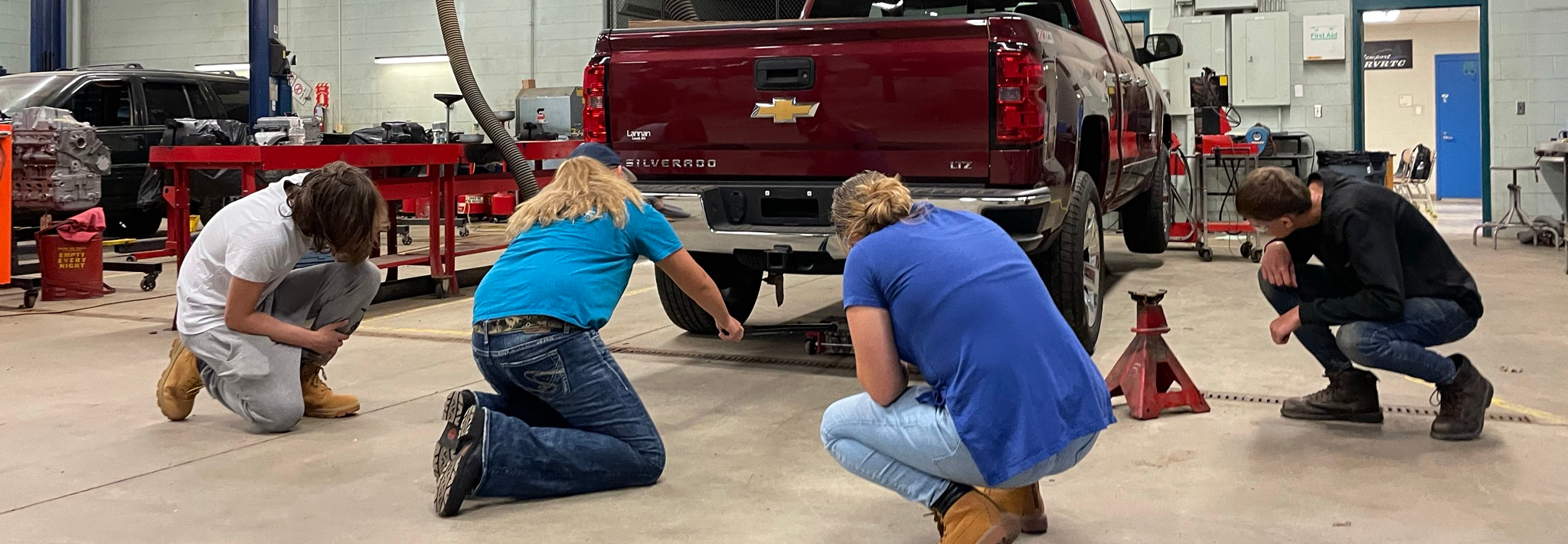 Students looking under truck in Auto lab