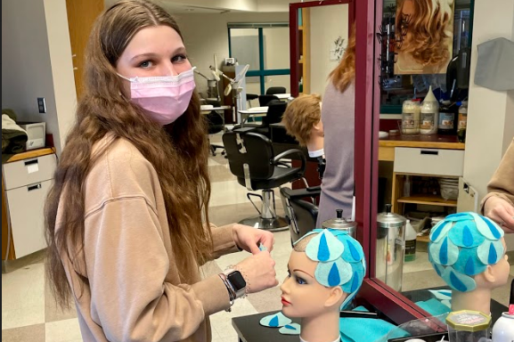 Cosmetology student working on a no hair project