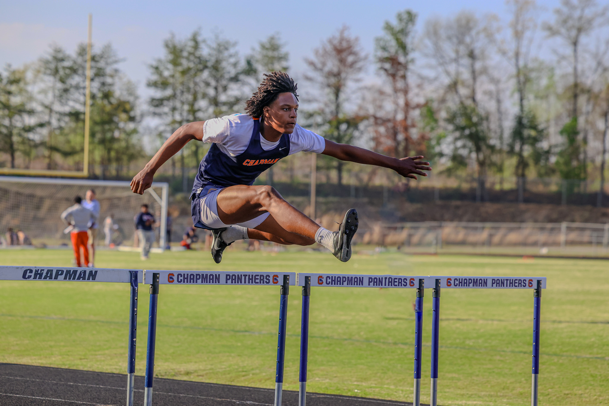 Chapman High School Track student going over the hurdles.