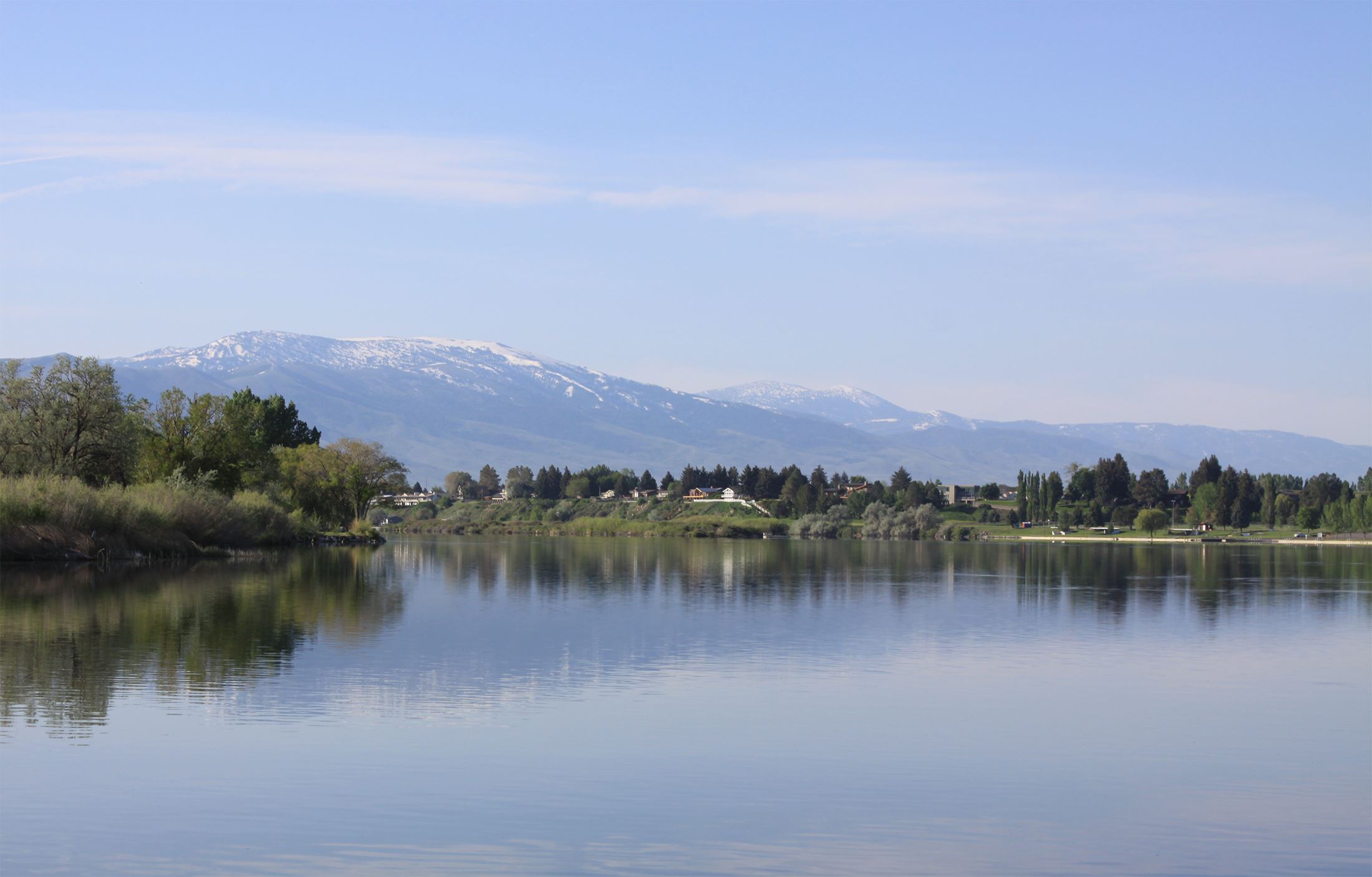 A lake with snowy mountains in the background