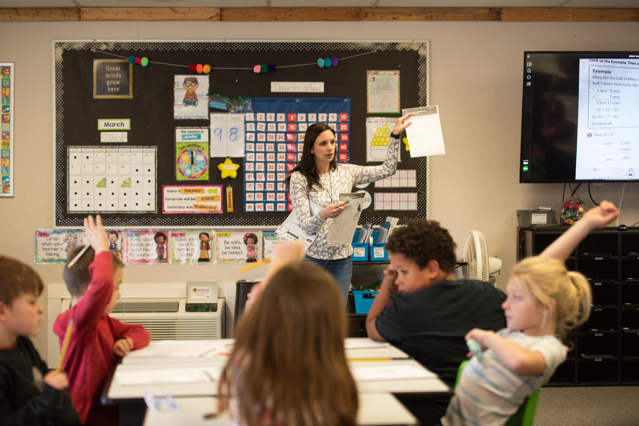 teacher in front of class with paper