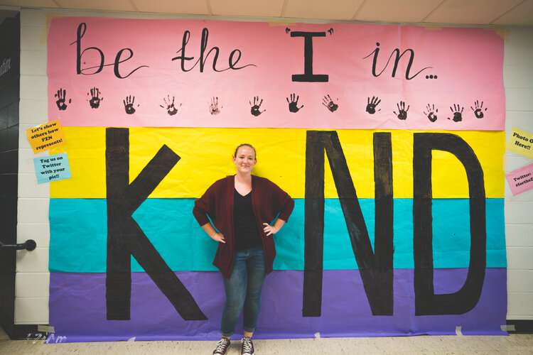 students creating and posing with kind sign