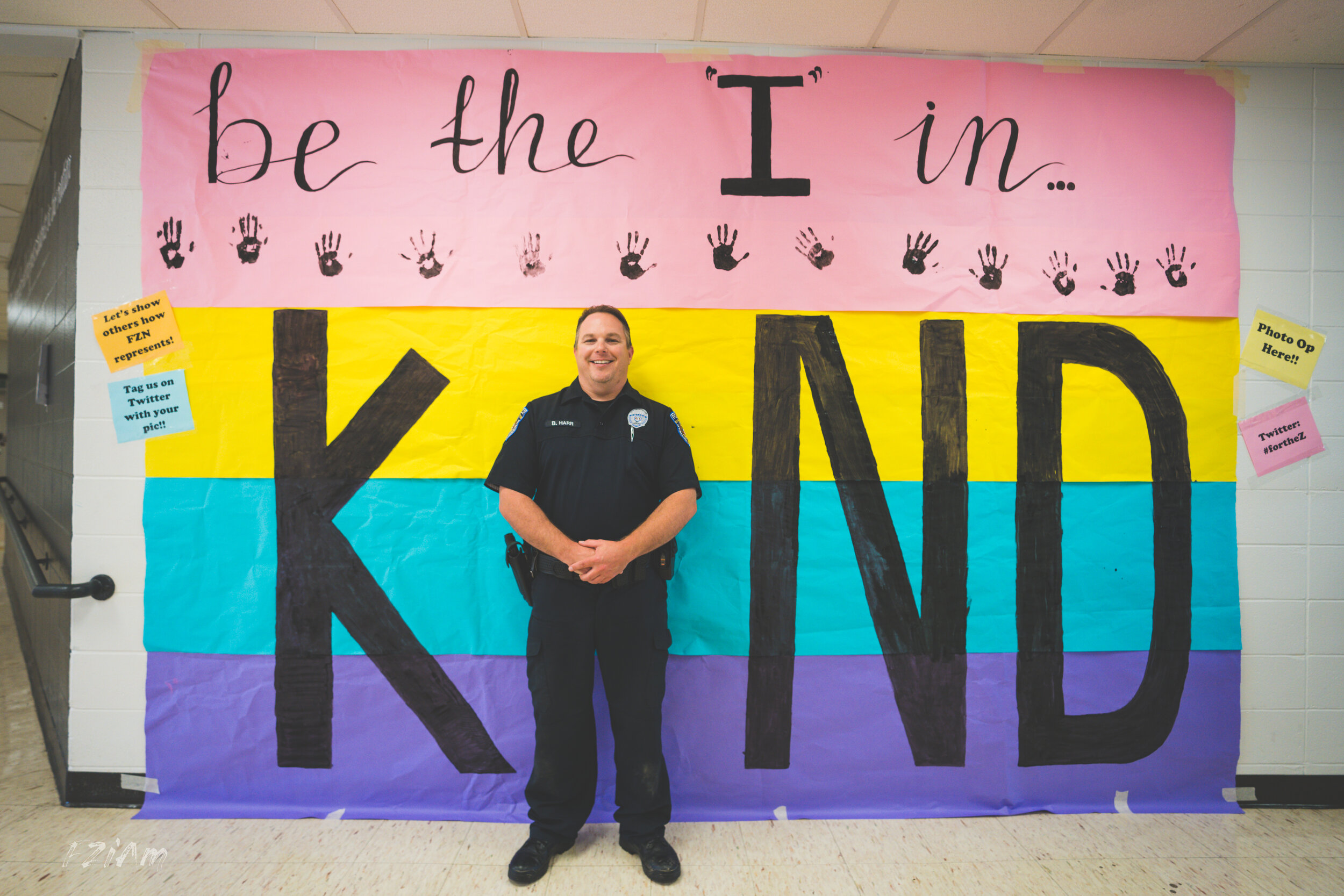 students creating and posing with kind sign