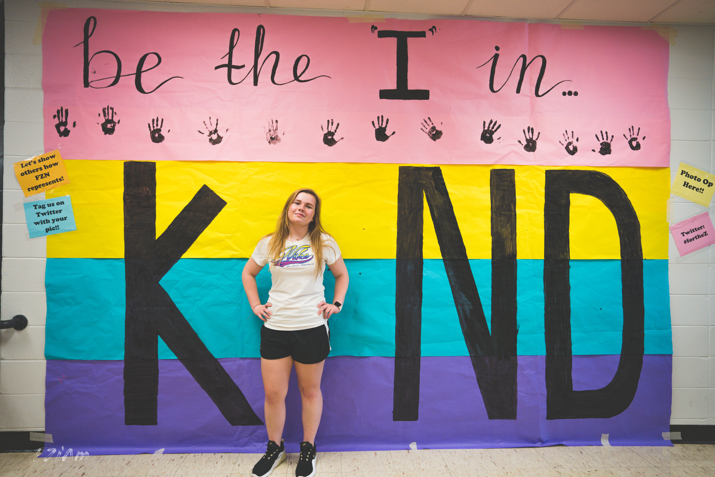 students creating and posing with kind sign