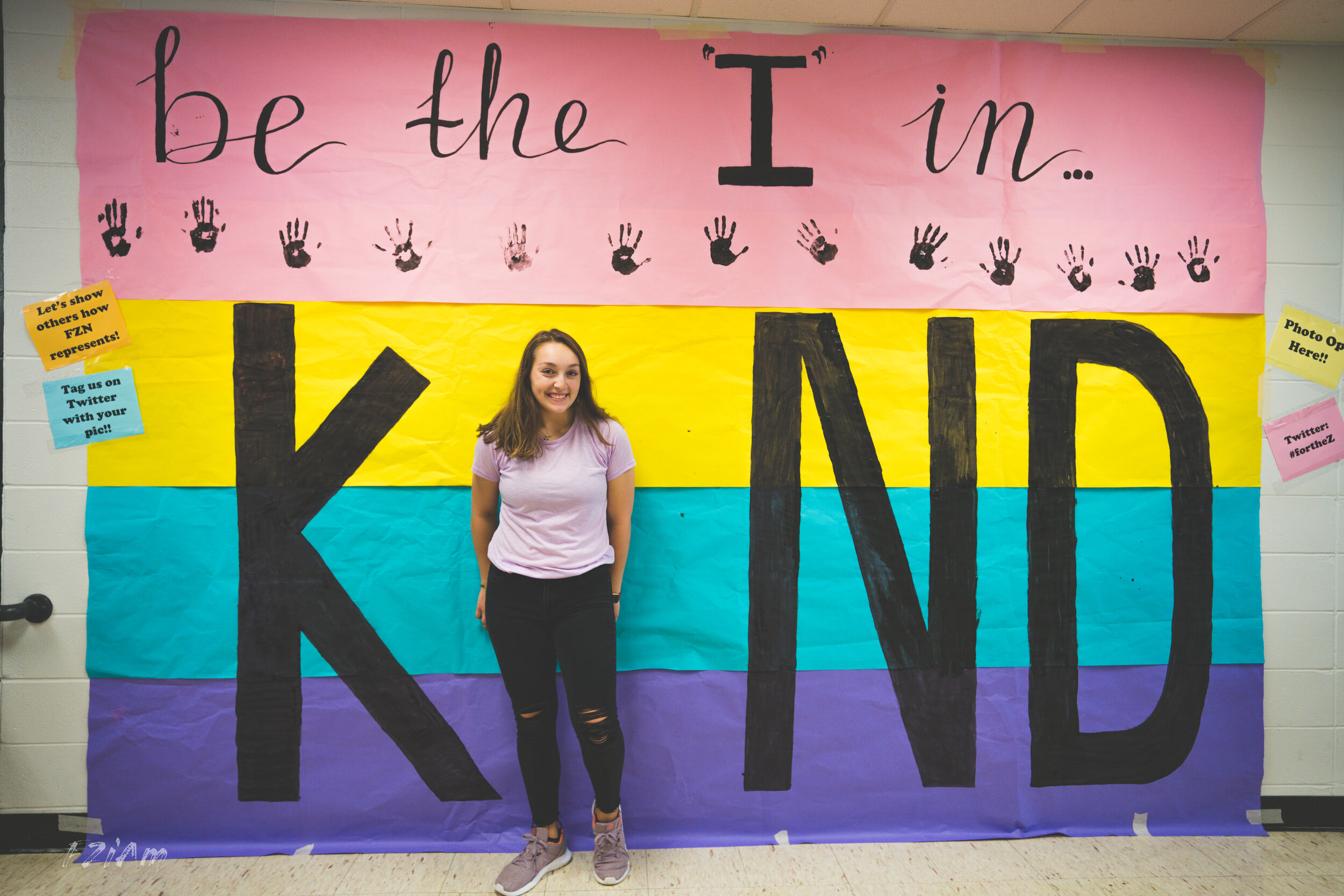 students creating and posing with kind sign