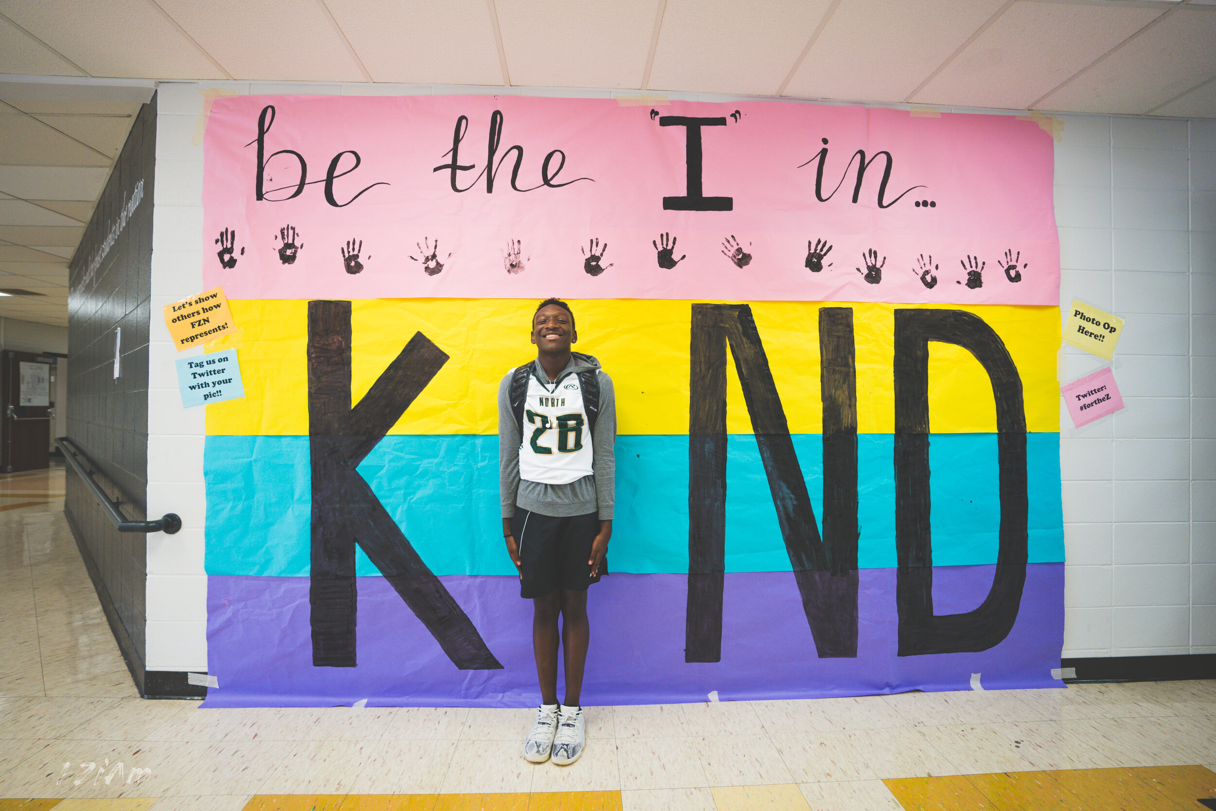 students creating and posing with kind sign