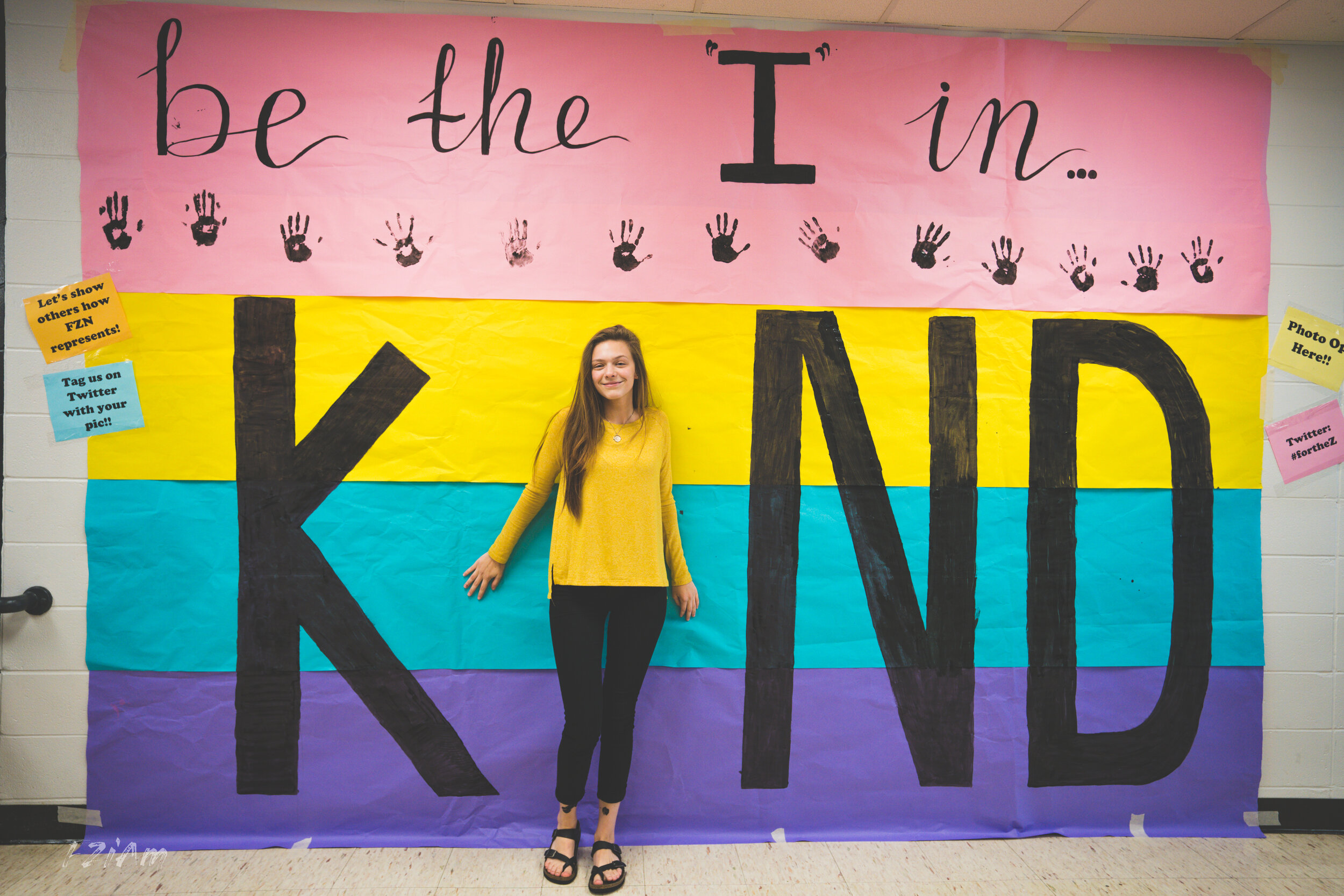 students creating and posing with kind sign