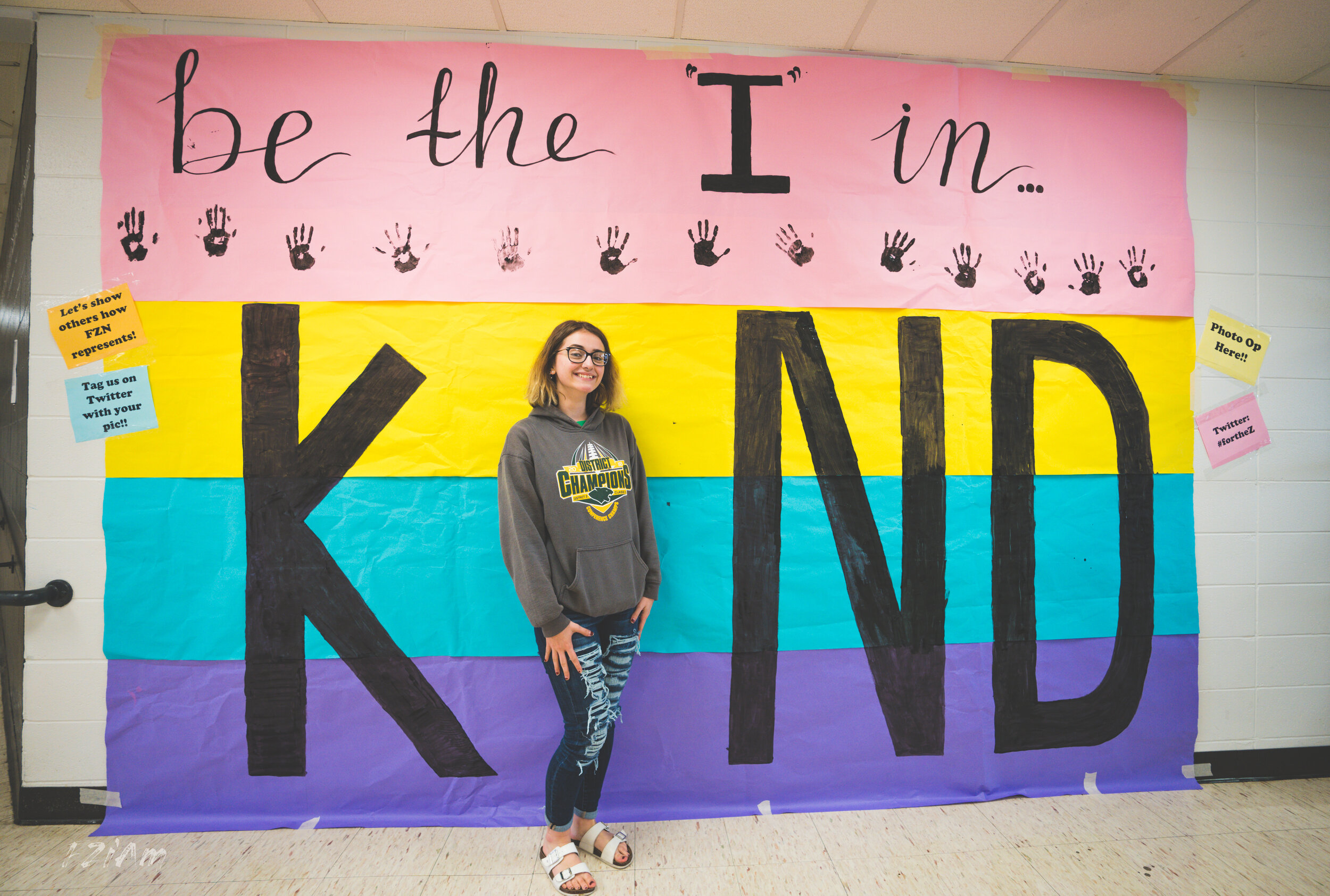 students creating and posing with kind sign