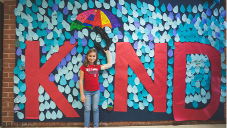girl in front of kind sign