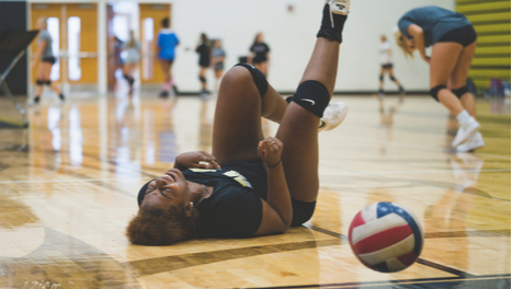 Girl on her back on volleyball court