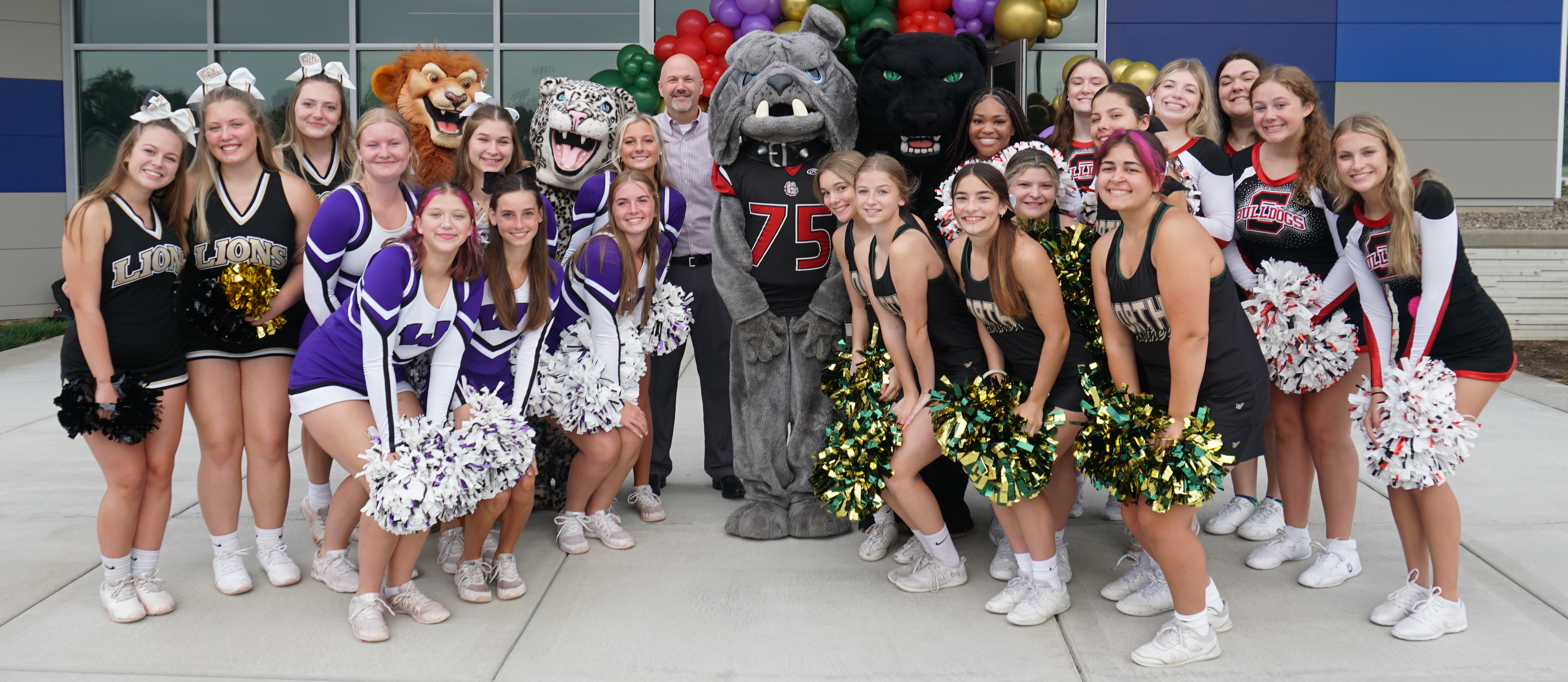 Superintendent with high school mascots and cheerleaders welcoming new educators to the school year