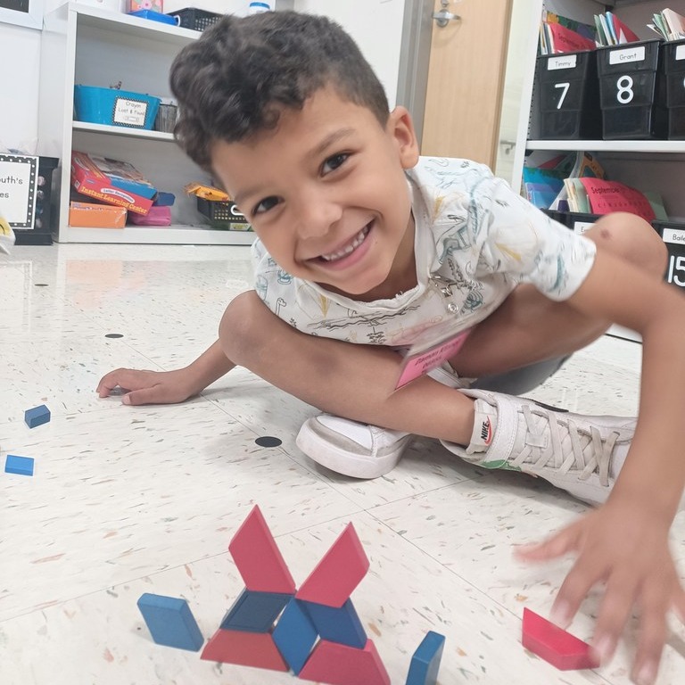 Kindergartener celebrates solving math problem with blocks
