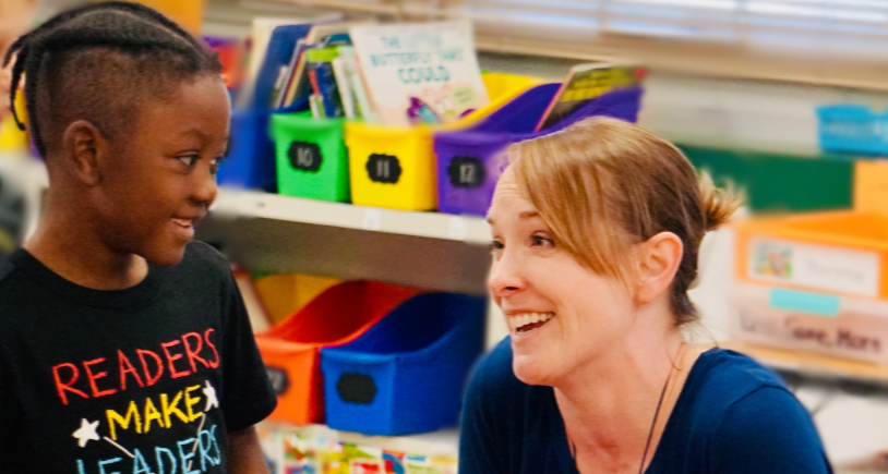 Teacher and student smile as they wonder together about what they just read in kindergarten