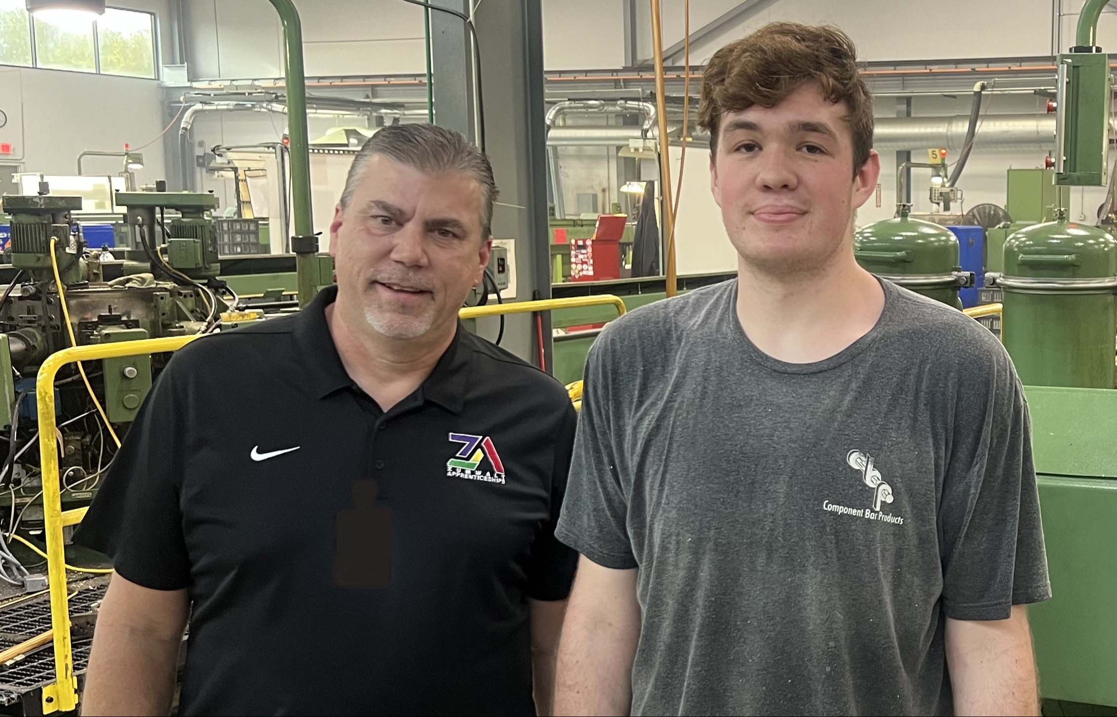 Mason Halbert in the shop at work with teacher and mentor