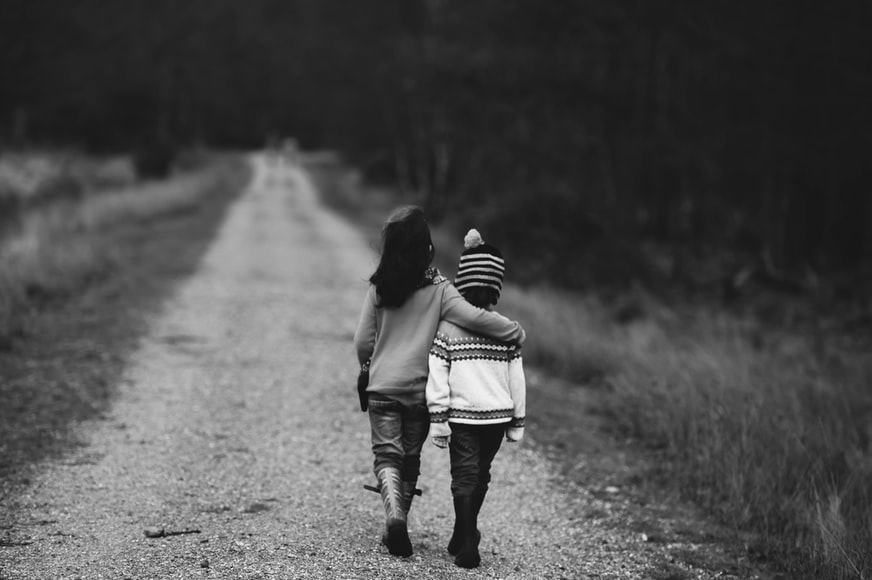 two girls walking, dirt road, arms around shoulders
