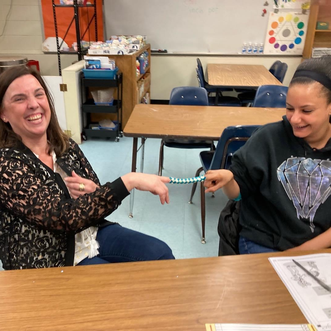 two adult females stuck in a finger trap, laughing
