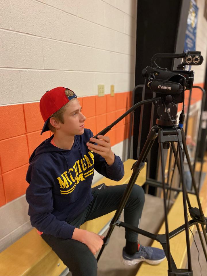 Student controlling the camera during a basketball livestream.