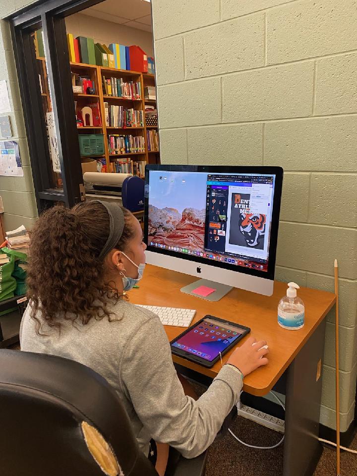 Student editing graphic for weekly announcements.