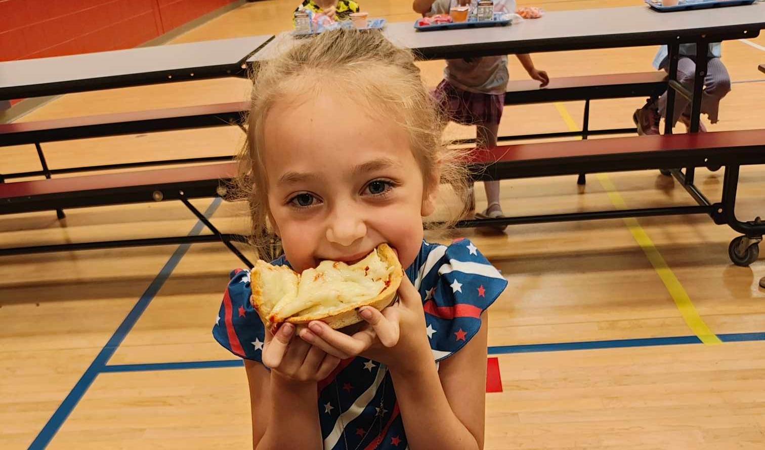 1st grader enjoying pizza for lunch