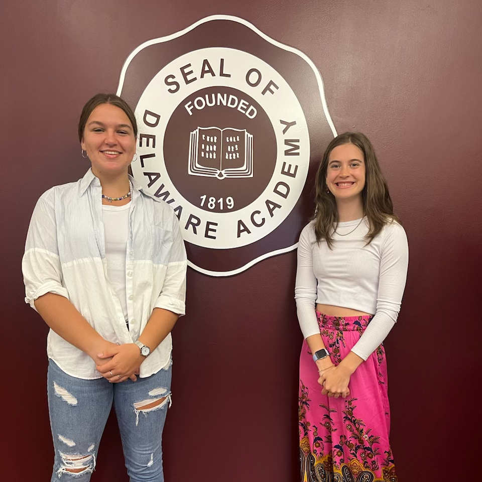 Victoria Verspoor and Erin Kennefick-Coppersmith standing next to DA seal