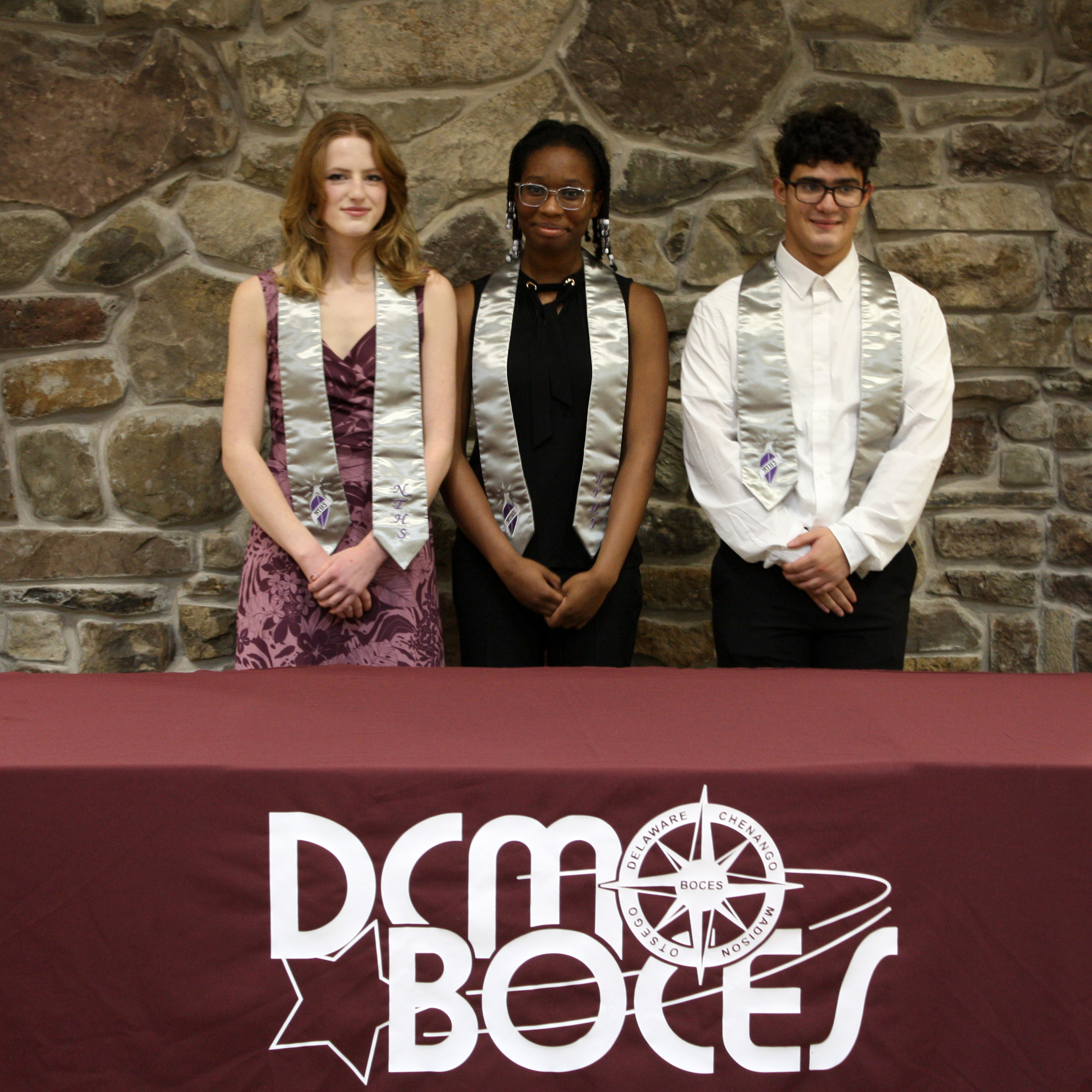 three students pose wearing their National Technical Honor Society stoles