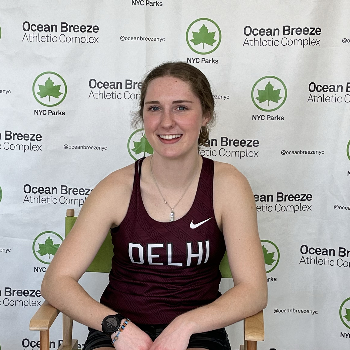 picture of Ellie Leers sitting in chair with Ocean Breeze Athletic Complex background