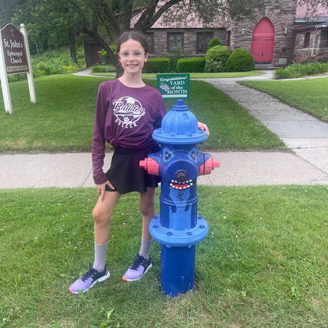 girl standing next to painted fire hydrant
