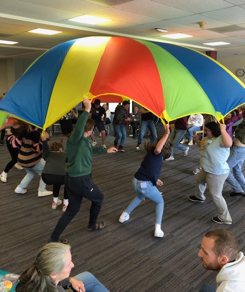 students playing with parachute