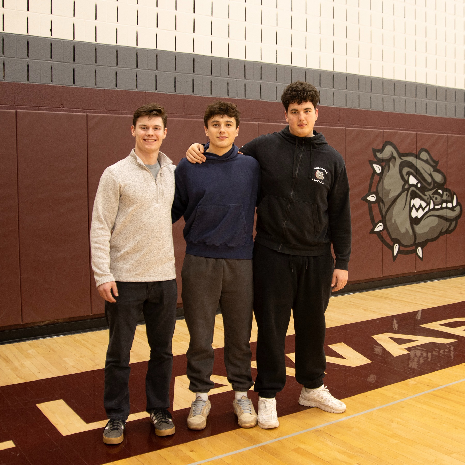 Adam Cook, Lucas Nealis and Steven Hillis pose in the gymnasium
