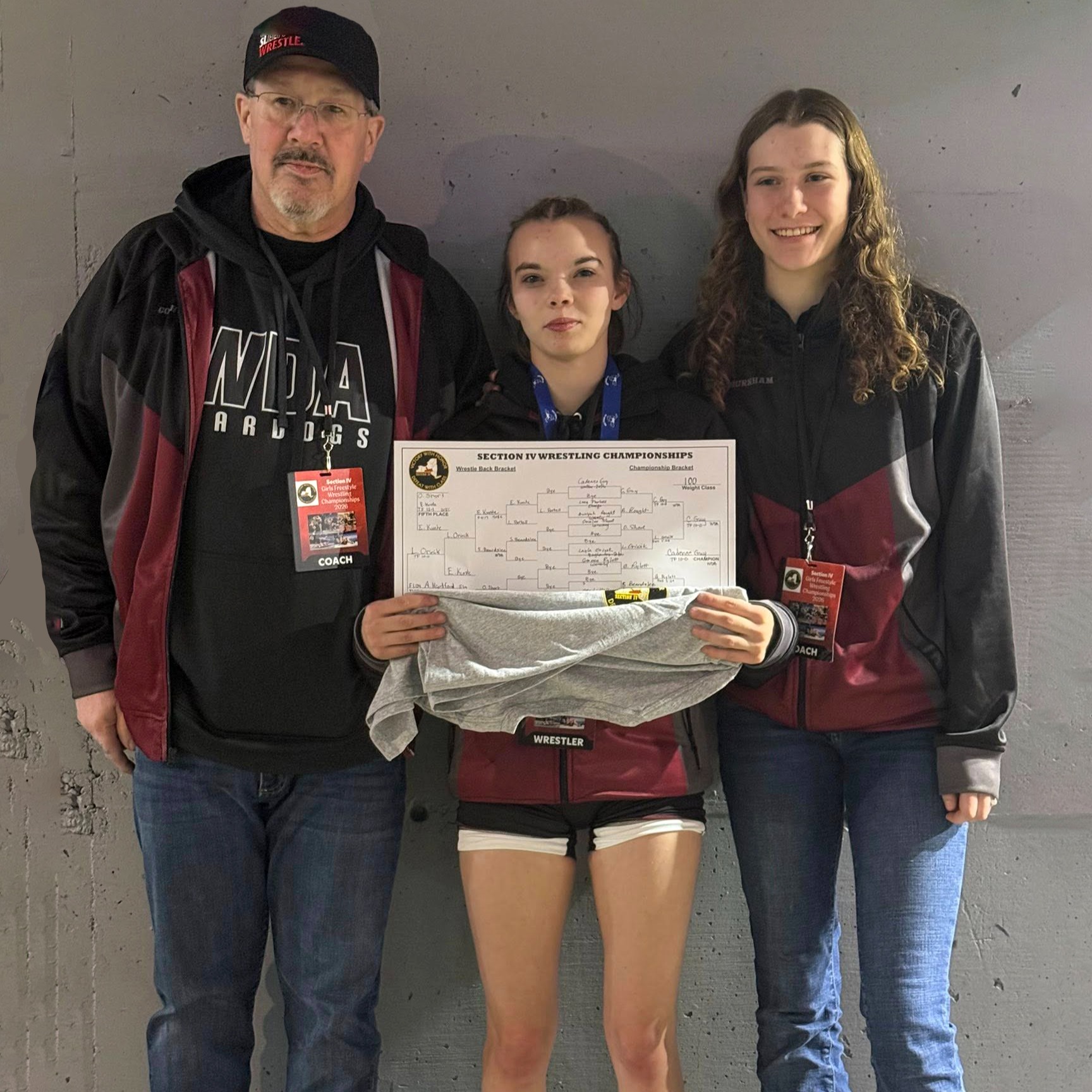 two wrestling coaches and Cadence Guy with wrestling bracket
