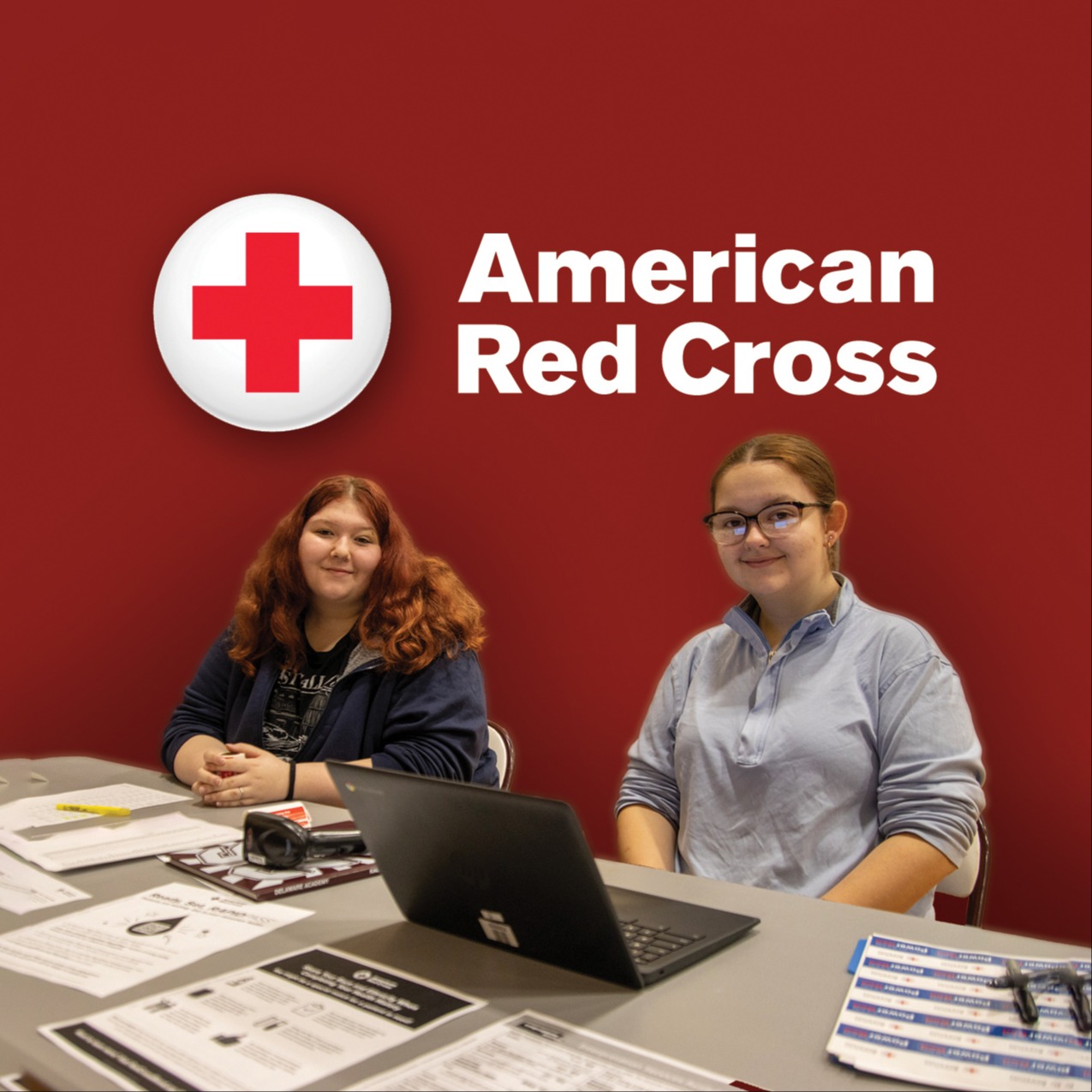 American Red Cross logo; two volunteers sitting at the check-in table