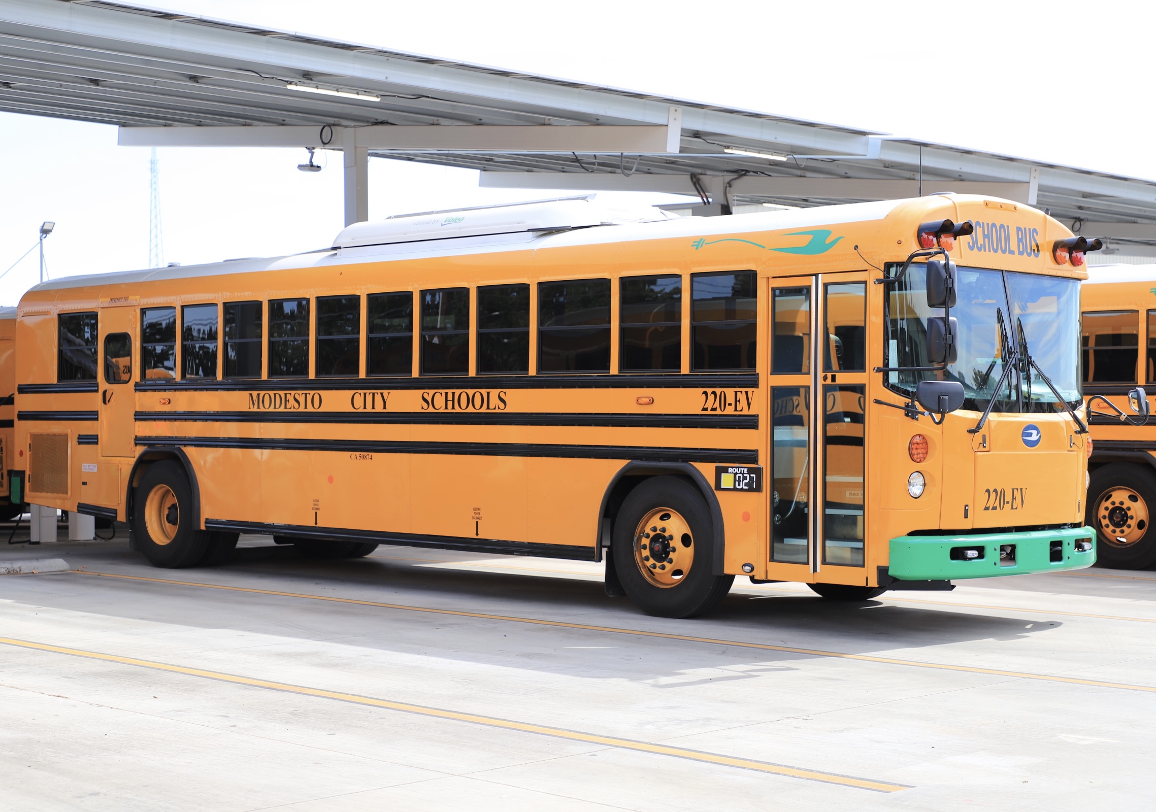 electric school bus at transportation yard under ev charging structure