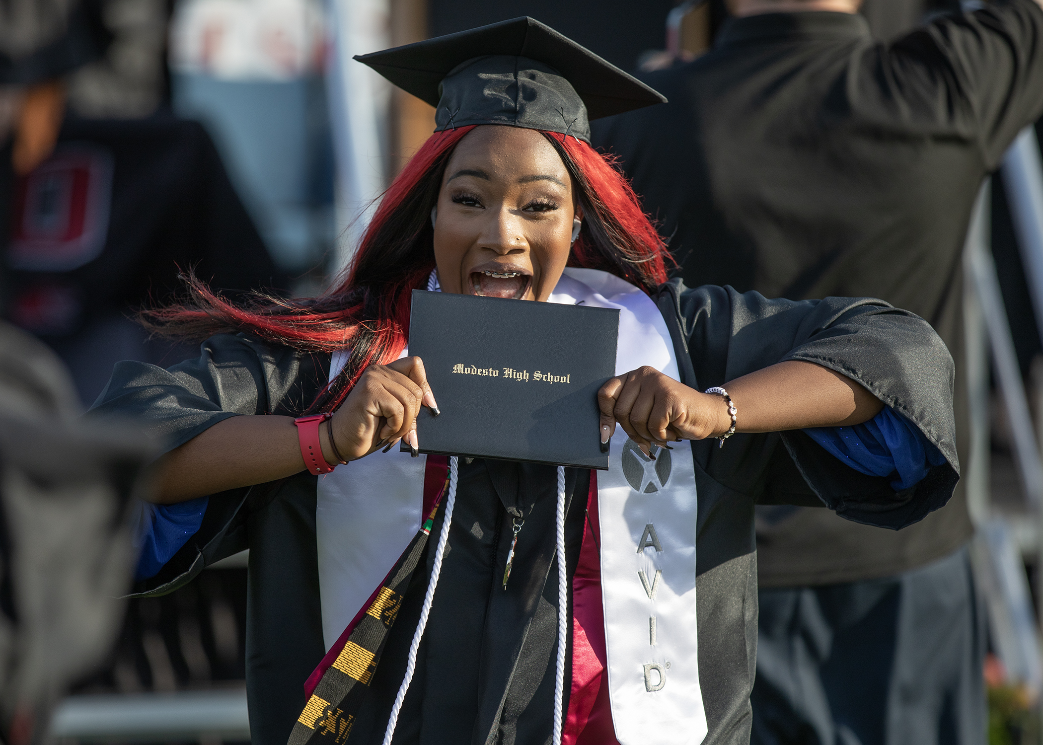 Modesto High graduate holding diploma at 2023 graduation