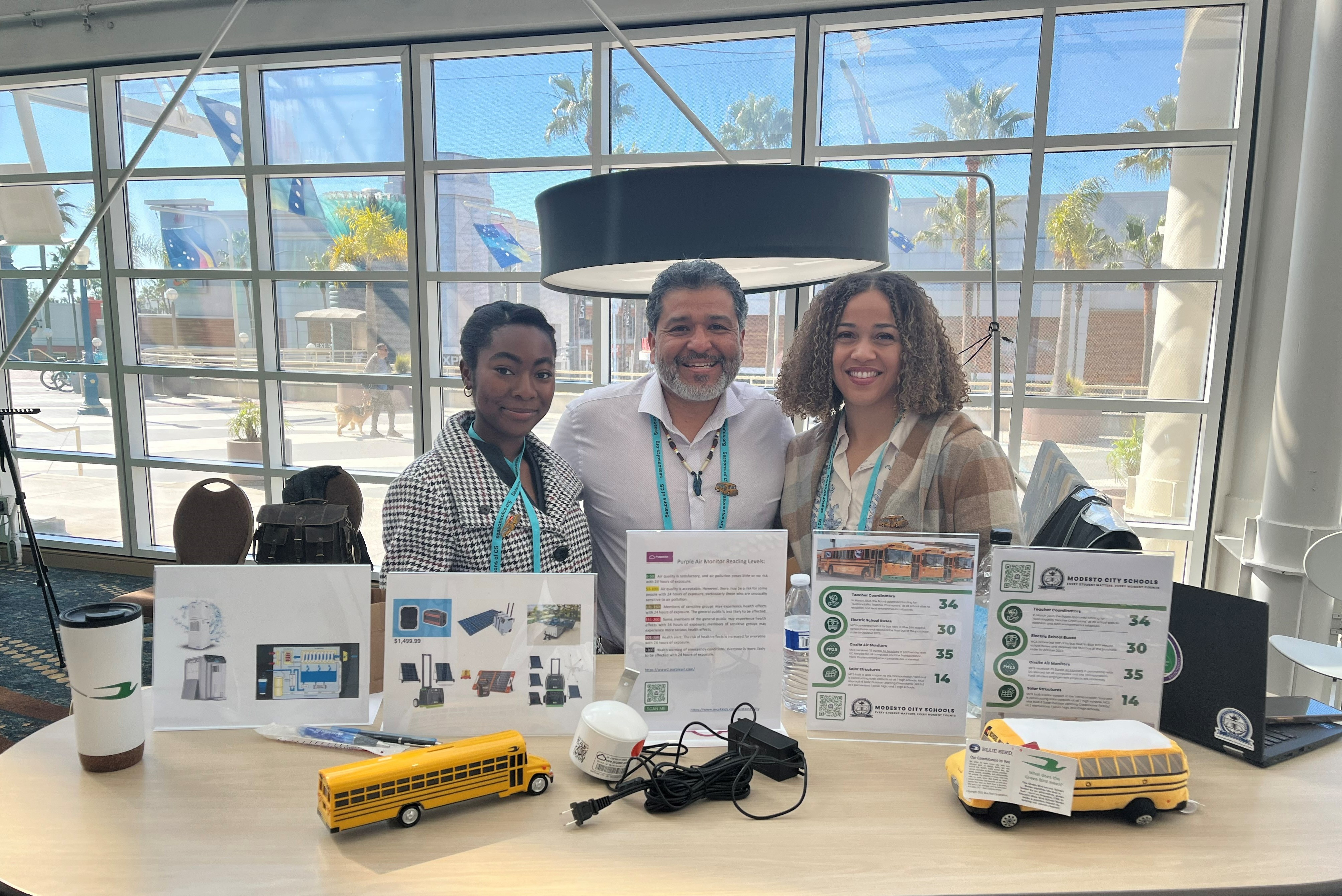 Student, Gilbert Blue Feather Rosas, and Fallon Ferris standing at their booth at the STEAM Symposium .