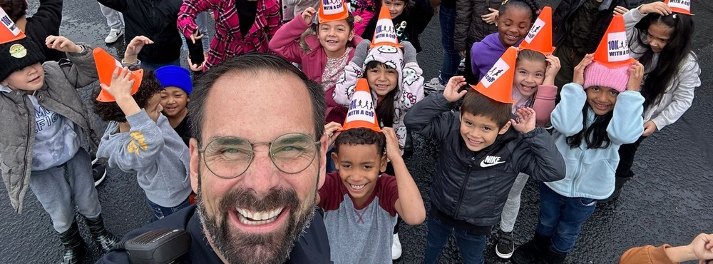 Modesto Police Officer Sean Dodge poses with a group of elementary students 