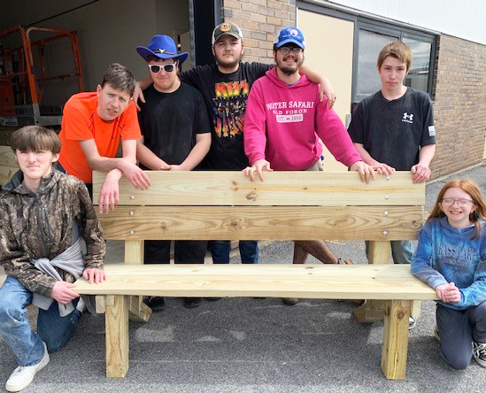 students showing off bench they built