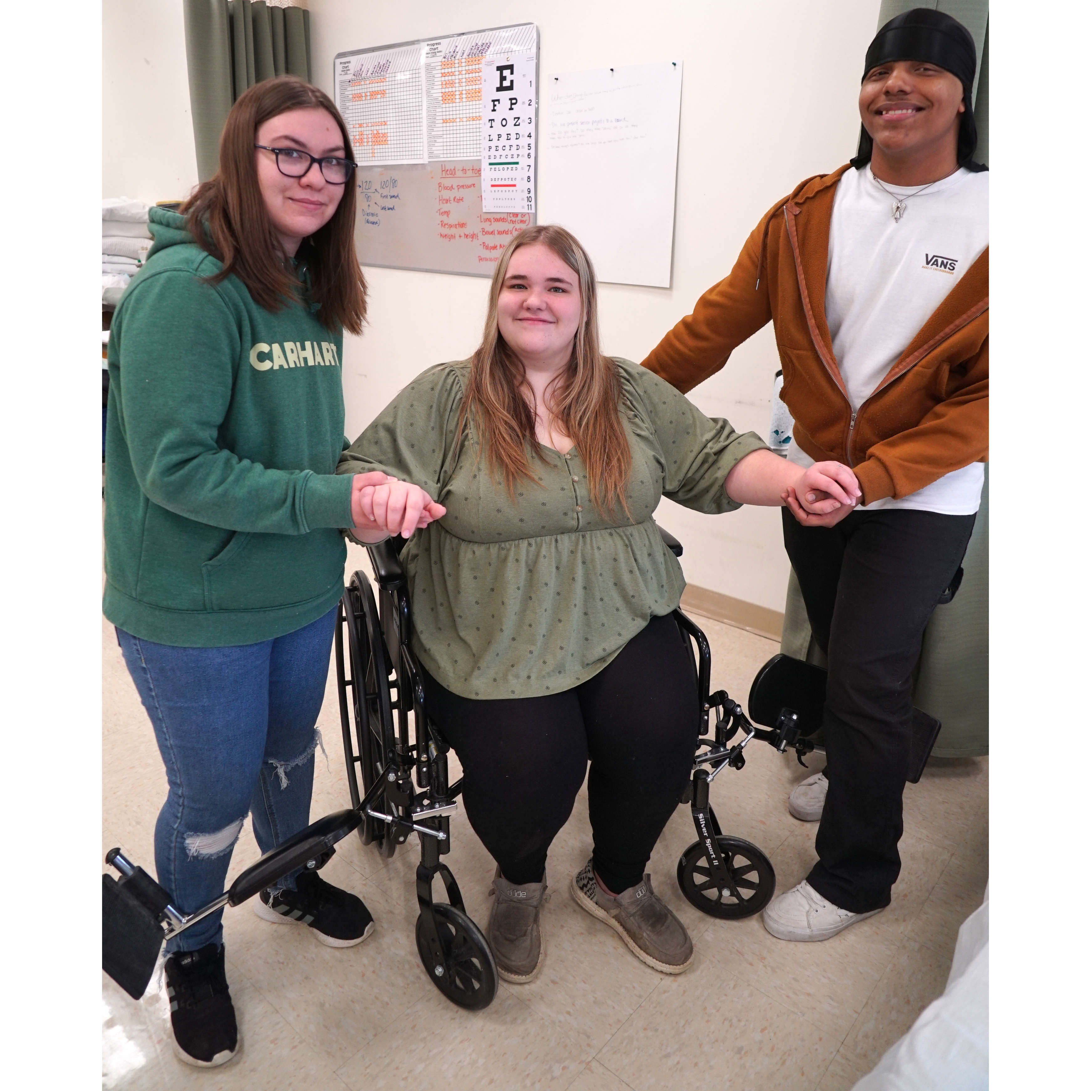 students assisting student in wheel chair 