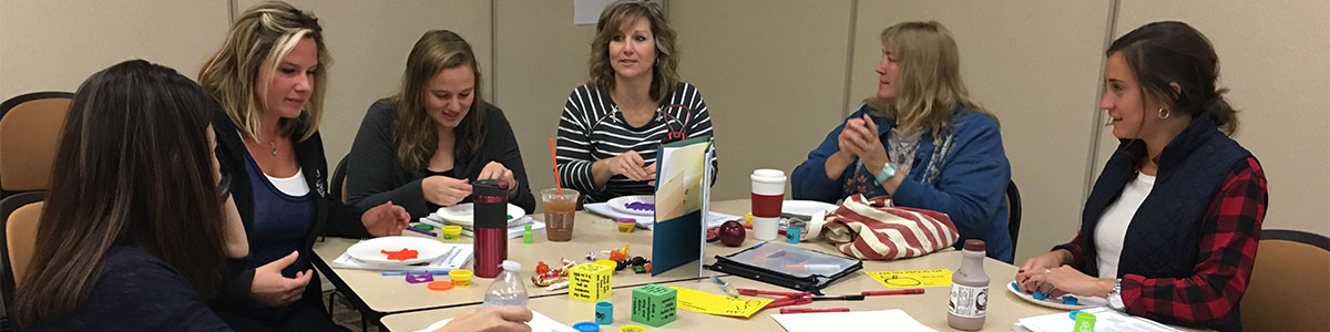 Faculty talking over an activity at a table