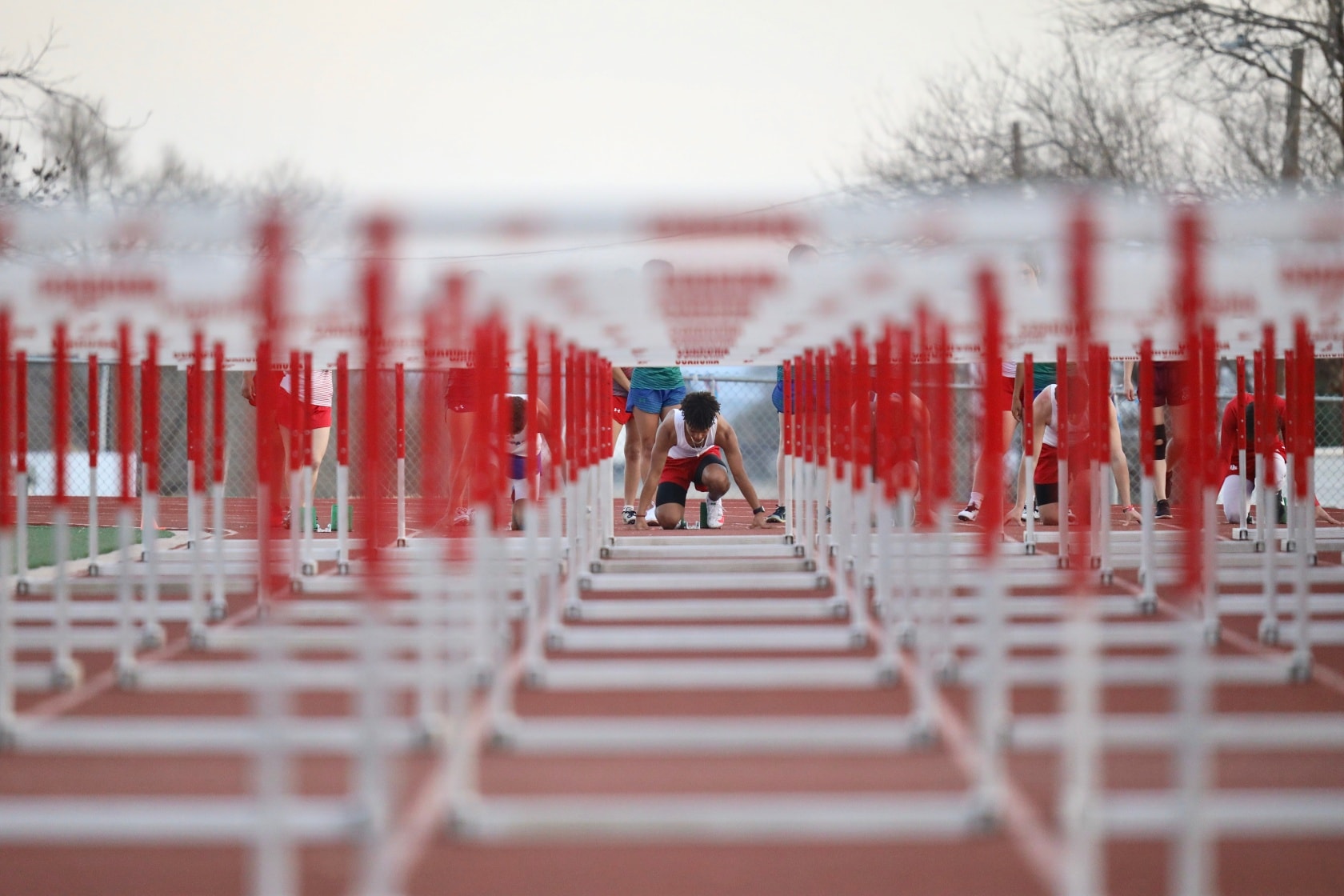 Rows of hurdles with a track athlete about to run a race