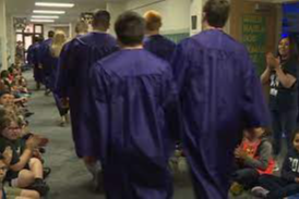 Angola High Scjool seniors walk through the halls of Angola Middle School in their caps and gowns