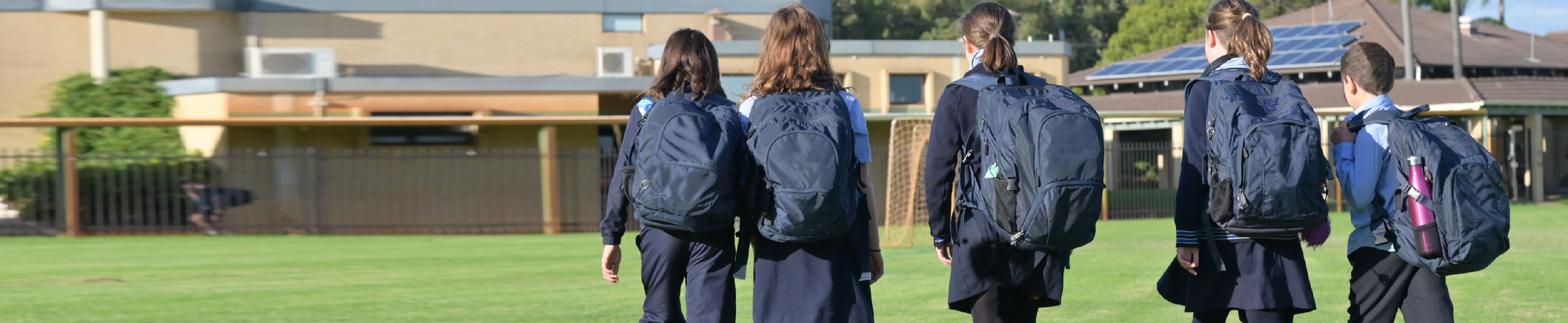 Students in uniform walking to school.