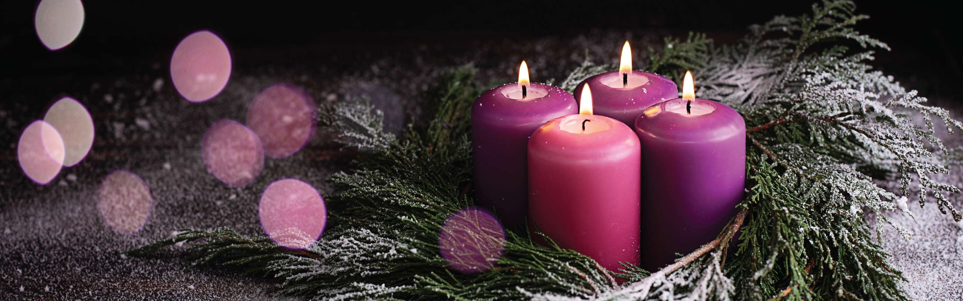 An image consists of 3 purple candles and 1 pink candle inside a wreath. 