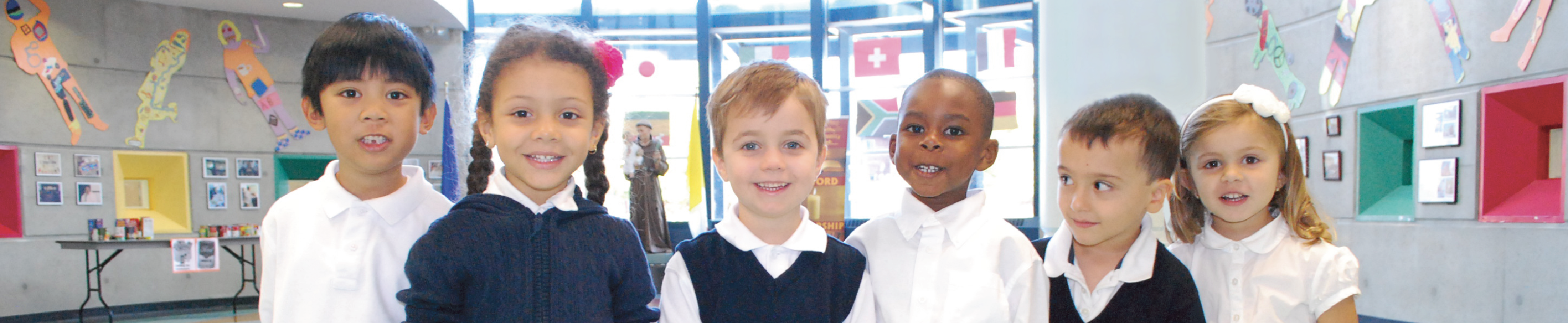 A group of children in uniform smiling at the camera.